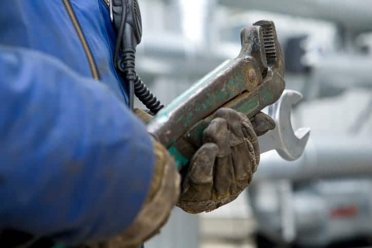 person holding a wrench representing skilled vs unskilled labor