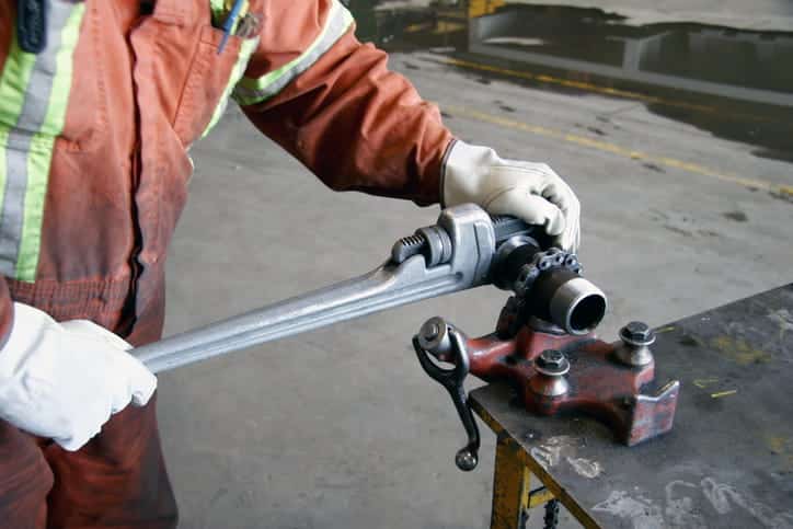 A pipefitter working on a pipe. 